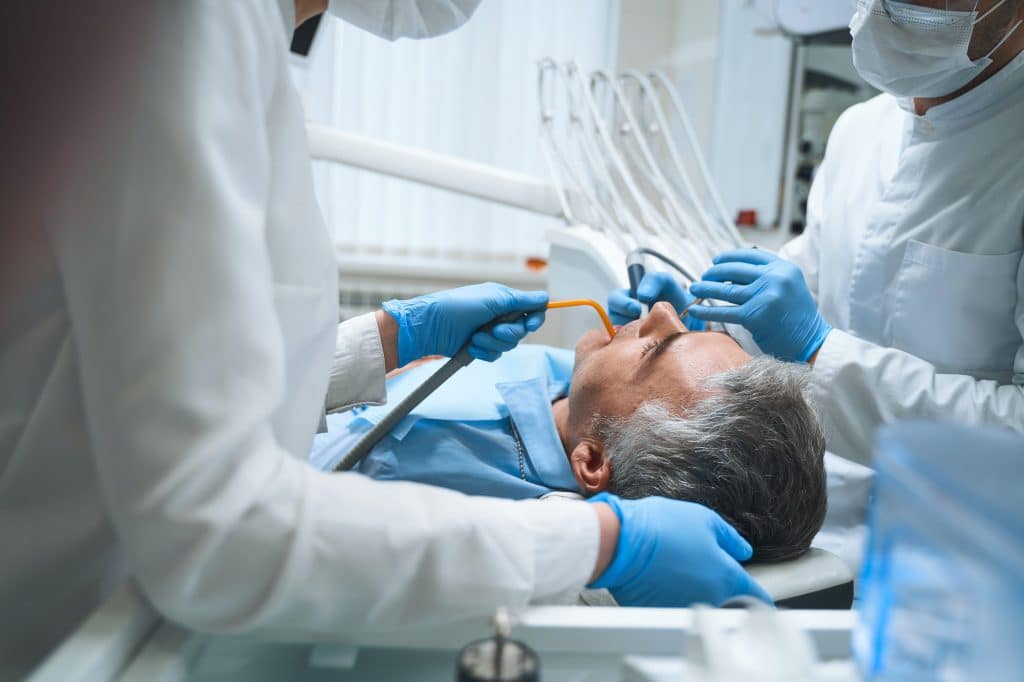 Male having teeth cured in clinic stock photo